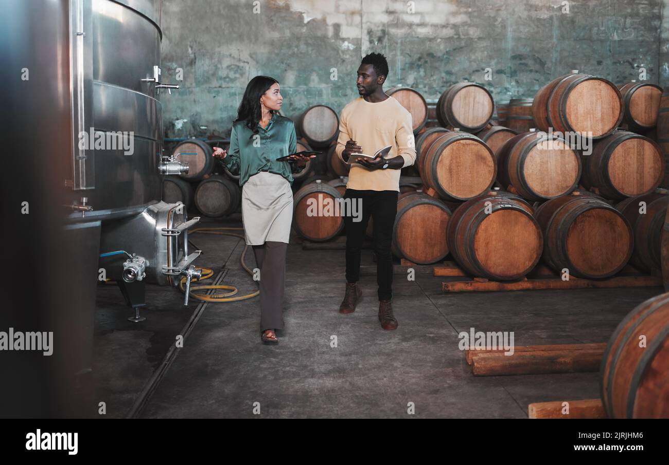 Wine cellar, warehouse and winery worker teaching a man about wine