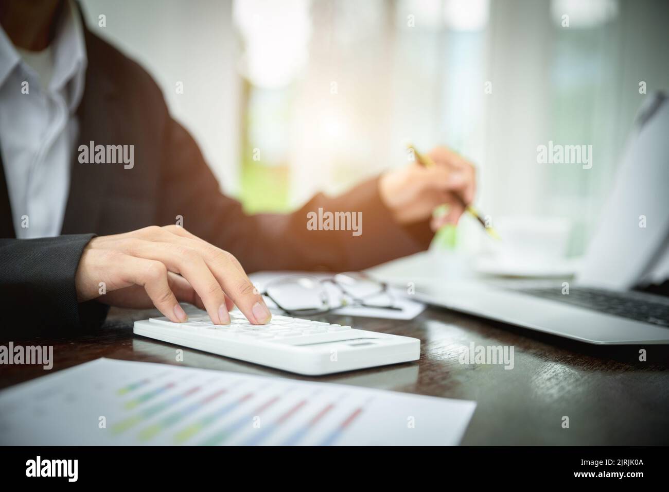 Young Businessman Analyzing Graph On Computer At Workplace Stock Photo