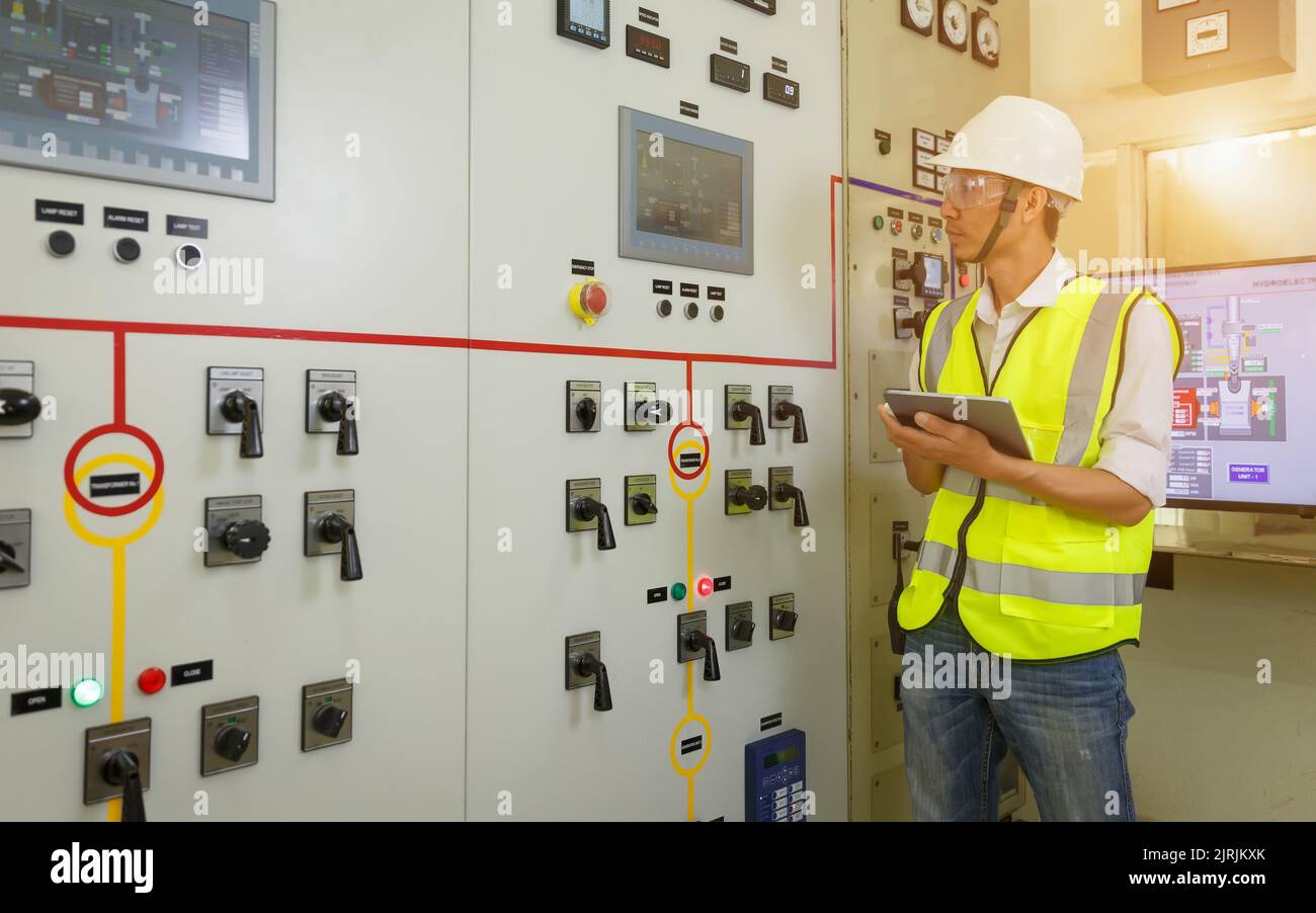 A male engineer working in an electrical control room in a heavy