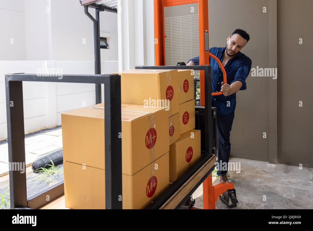 A man with carton boxes moving into new home. Stock Photo
