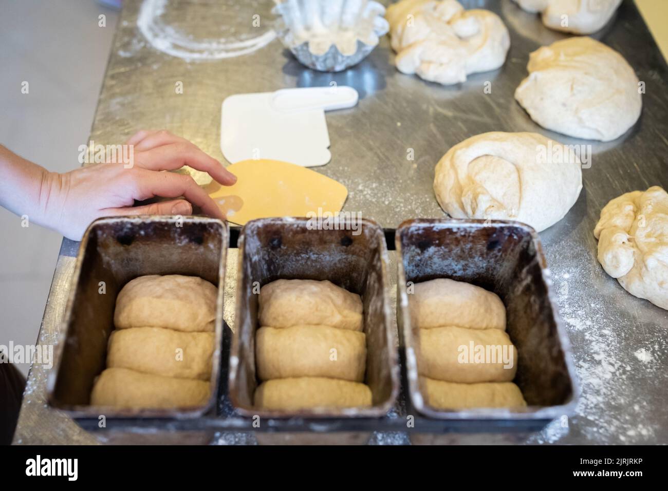 The process of making brioche in an artisan bakery. Laying the dough in