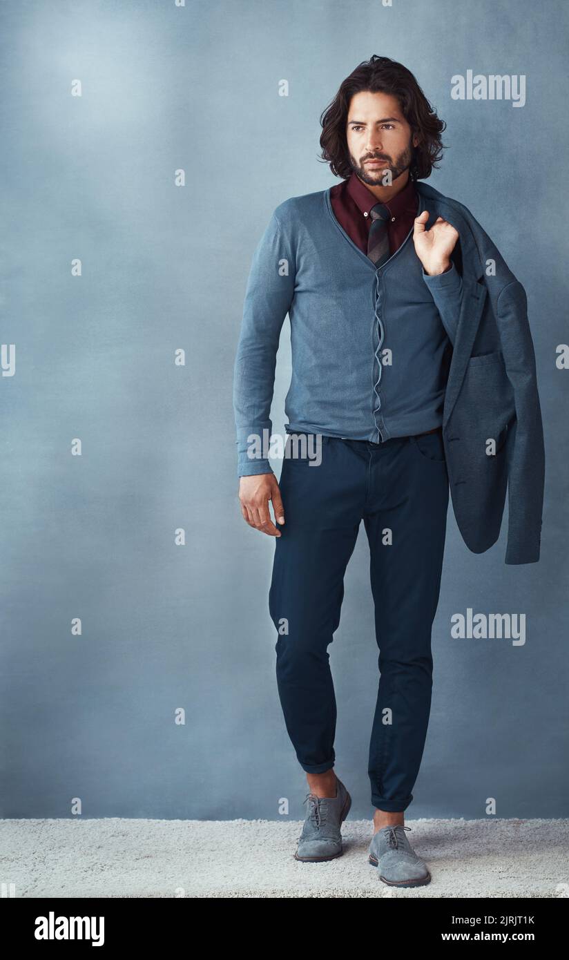 All style from head to toe. Studio shot of a handsome and dapper young man posing against a grey