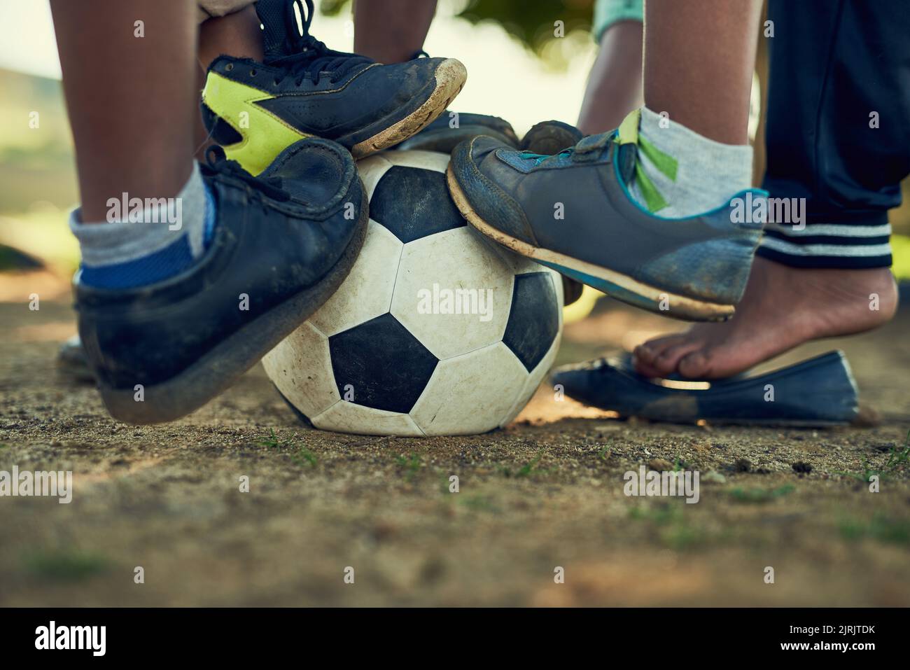 Future stars in the making. a group of children standing together on a soccer ball on a field outside. Stock Photo