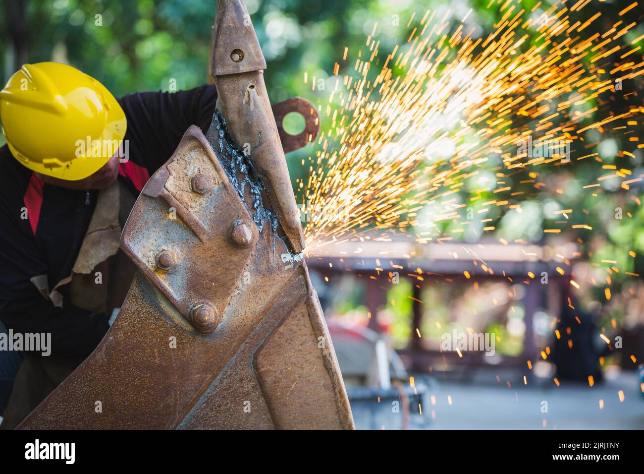 Metal workers use manual labor, steel cutting tools to cut steel. Cut metal. Grinding steel in a factory. Stock Photo
