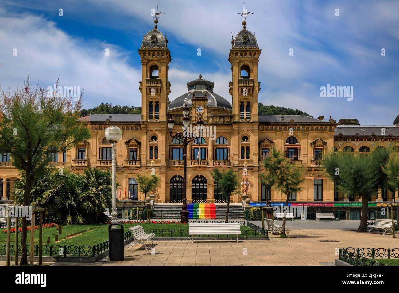 San Sebastian, Spain - June 26 2021: Ornate City Hall facade at the Alderdi Eder Gardens Park with a LGBT pride rainbow flag on the front steps Stock Photo
