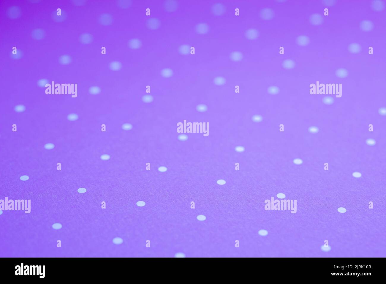 Full frame abstract texture background of solid purple and white polka dots pattern with selective focus Stock Photo
