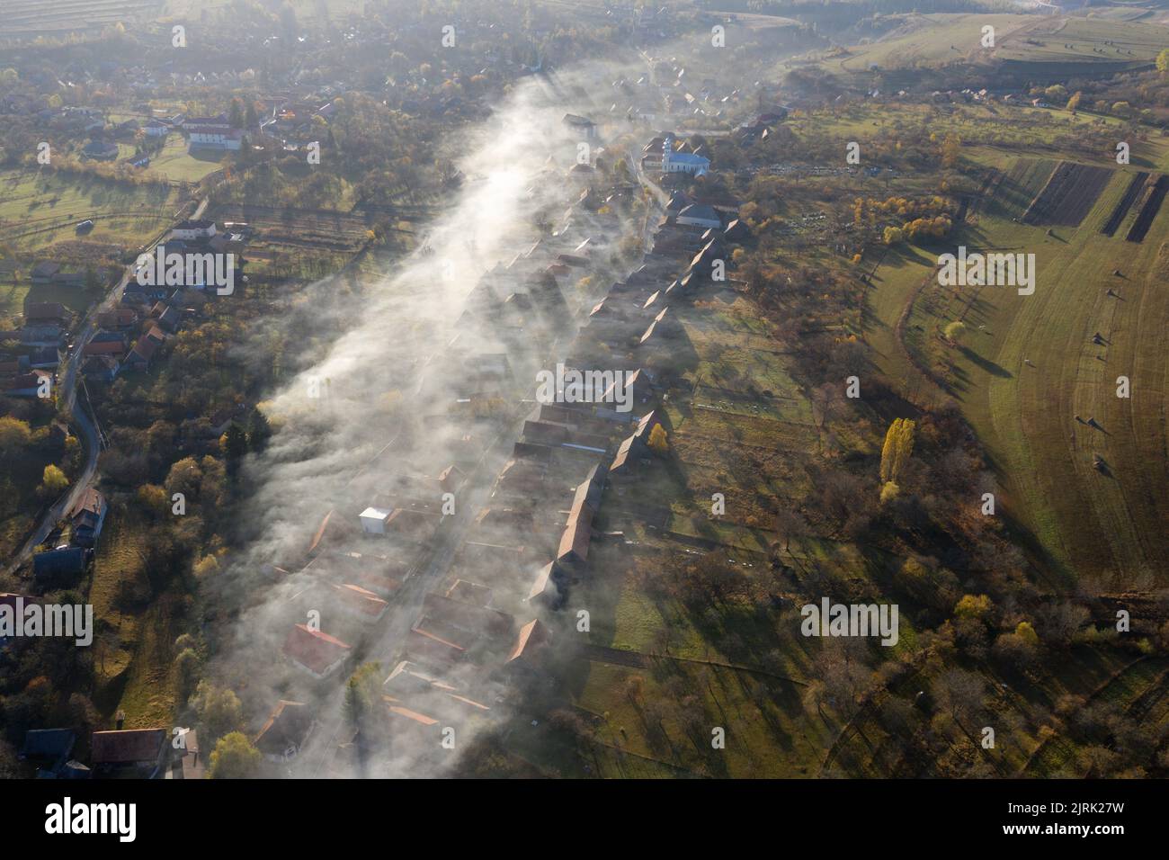 Aerial drone view of morning haze and mist above village houses. Manastireni, Romania Stock Photo