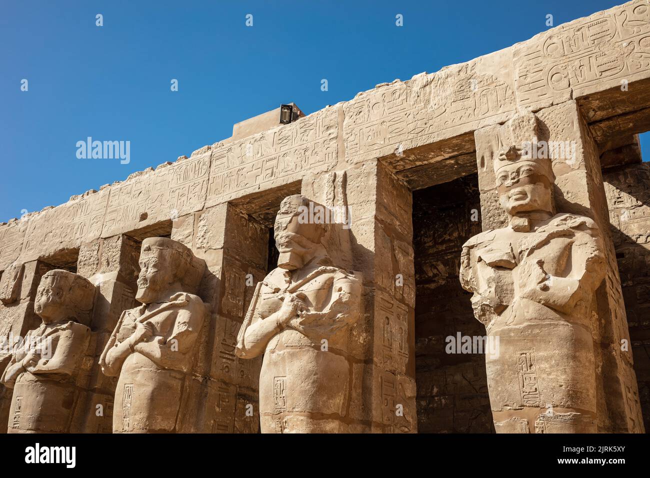 Statues of ancient Egyptian pharaohs and gods. Various hieroglyphs on