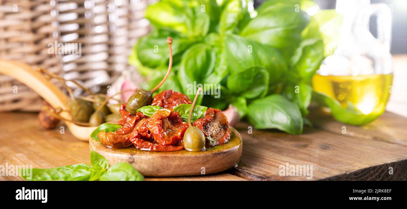 Dried tomatoes with herbs and olive oil. Traditional canned tomatoes in