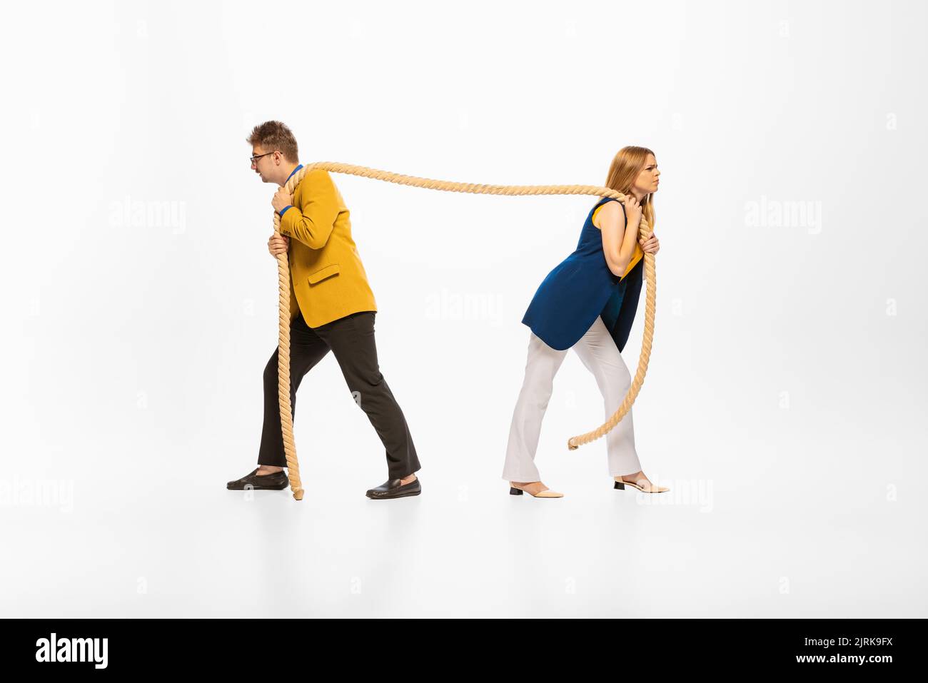 Portrait of young man and woman in official clothes pulling rope ...