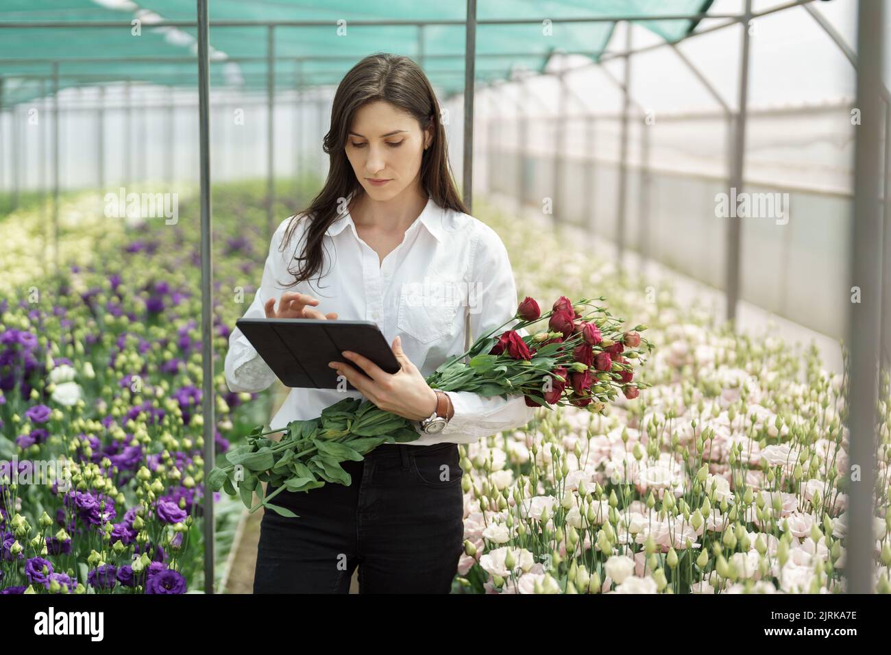 Fresh flowers delivery, women taking order on the tablet. Businesswoman using technologies in