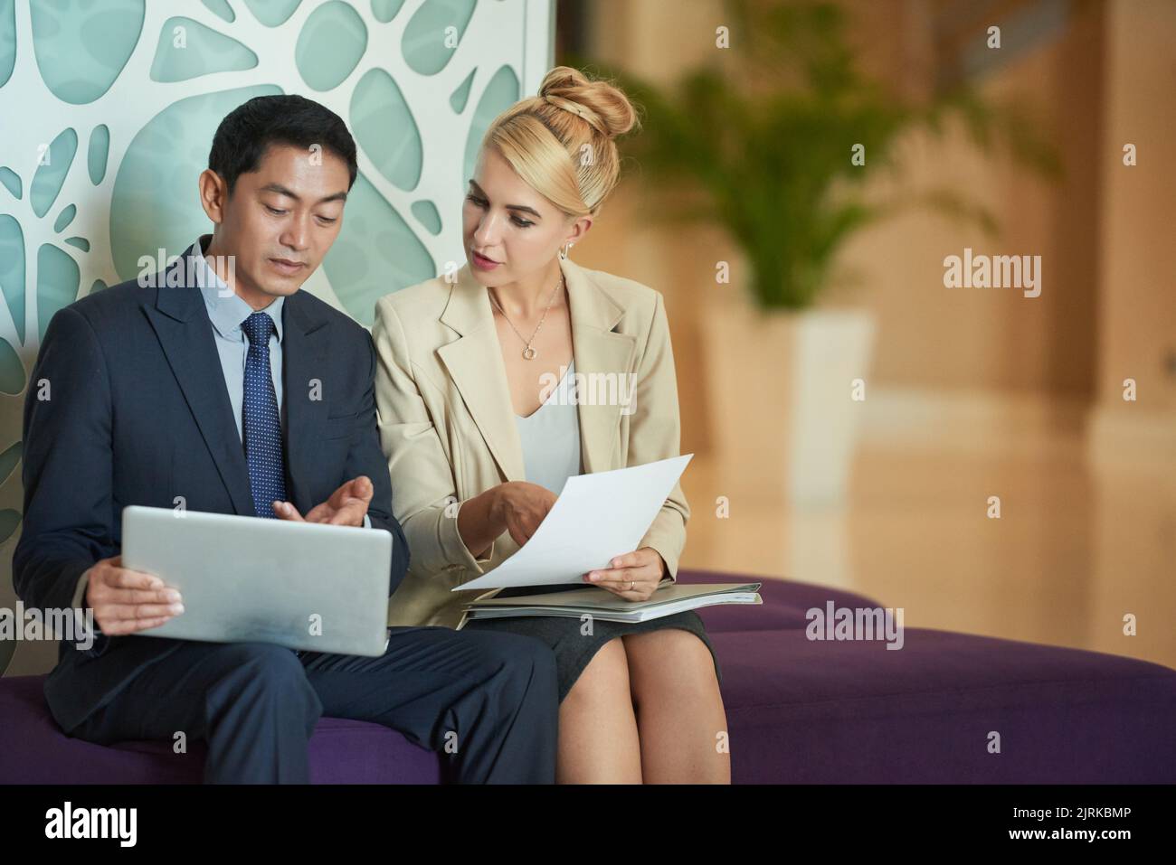 Colleagues discussing data on digital tablet and document Stock Photo