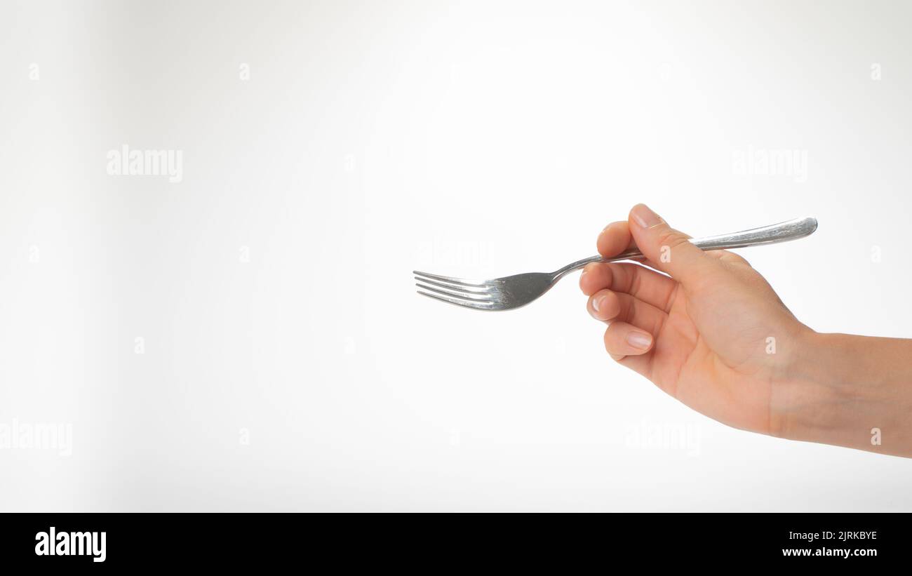 Fork in the right woman hand gesture to eat on a white background. High quality photo Stock Photo