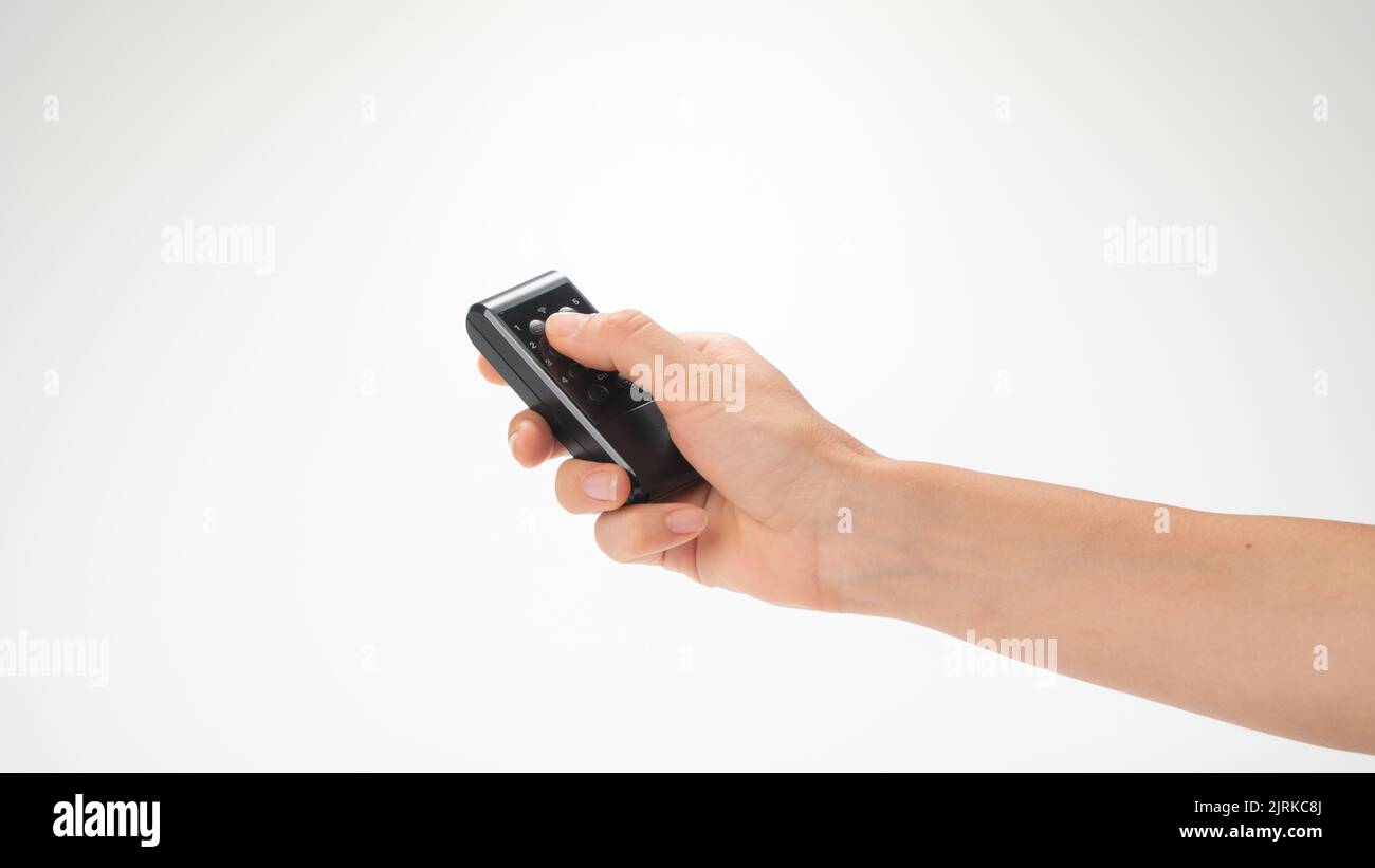 Female hand with remote control pointed upwards on a white background. High quality photo Stock Photo