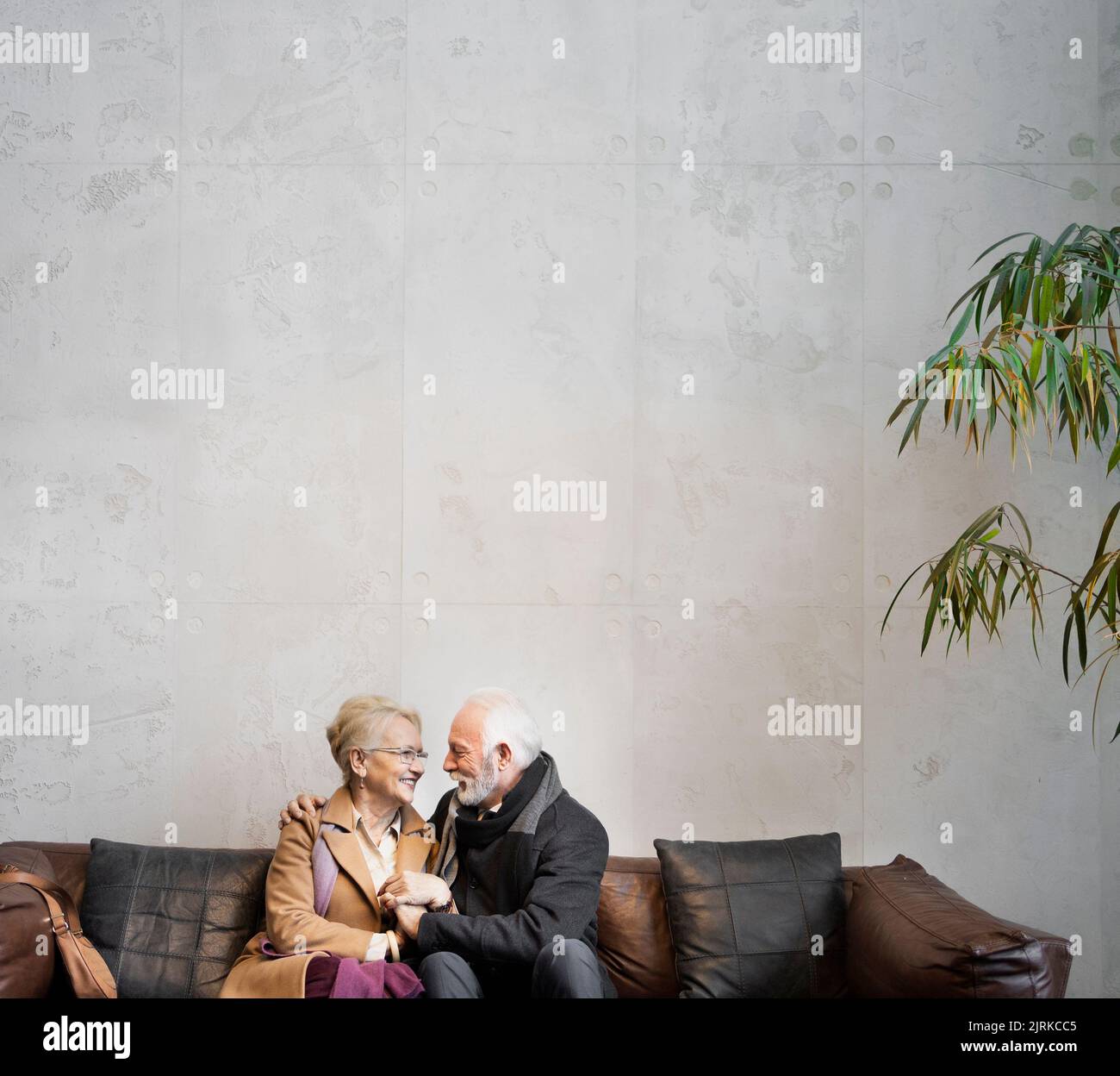 Elderly couple in love sitting in the hotel lobby Stock Photo