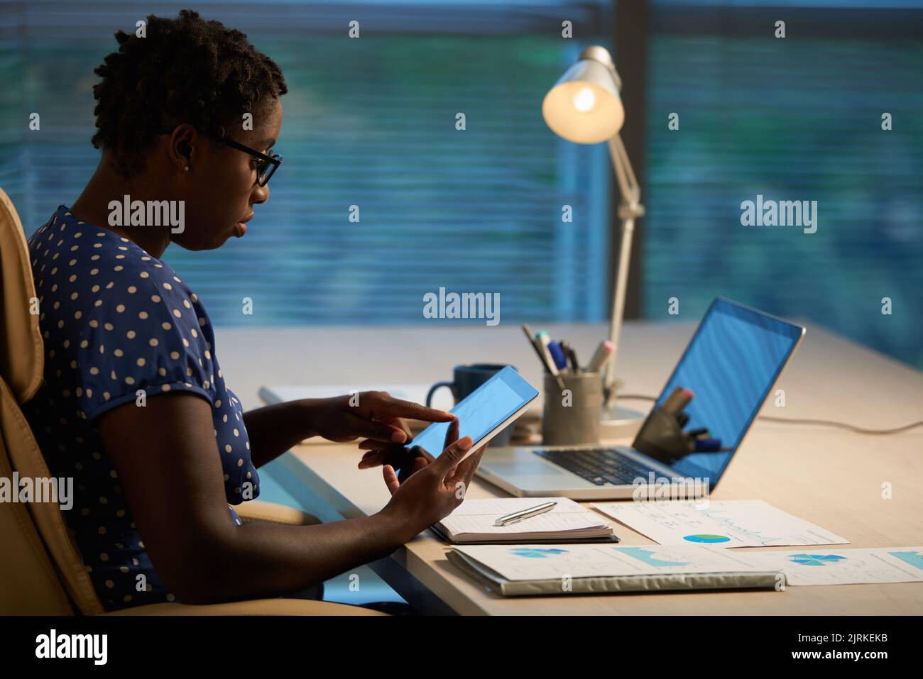 Female financial manager using digital tablet when working on project Stock Photo