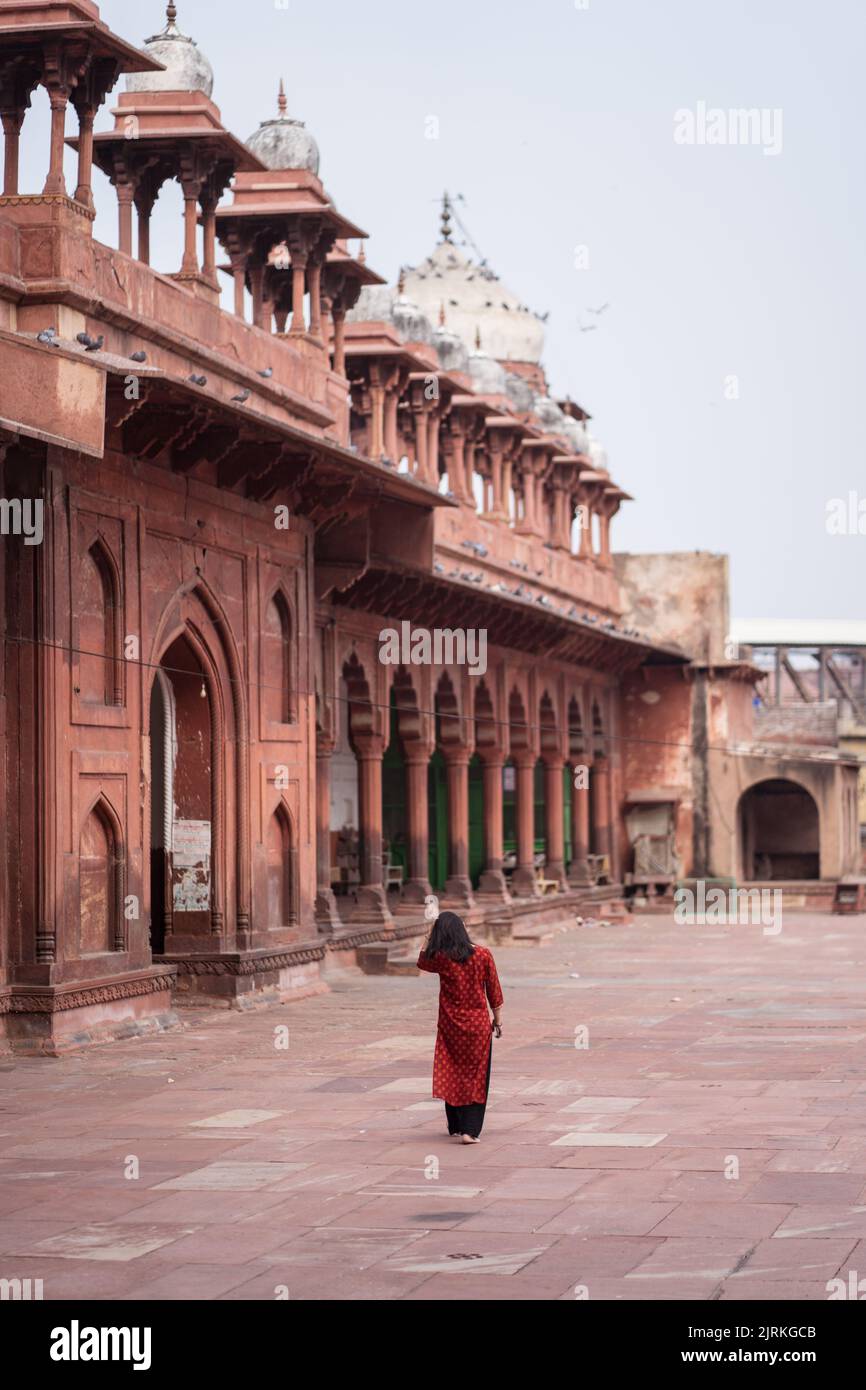 Back view of unrecognizable woman walking barefoot in weathered ...