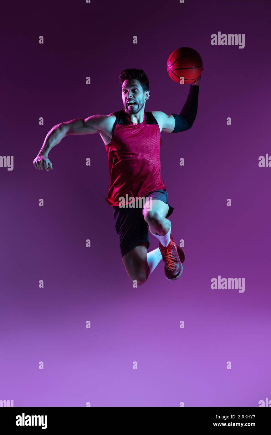 Creative studio shot of basketball player in studio using colored gels