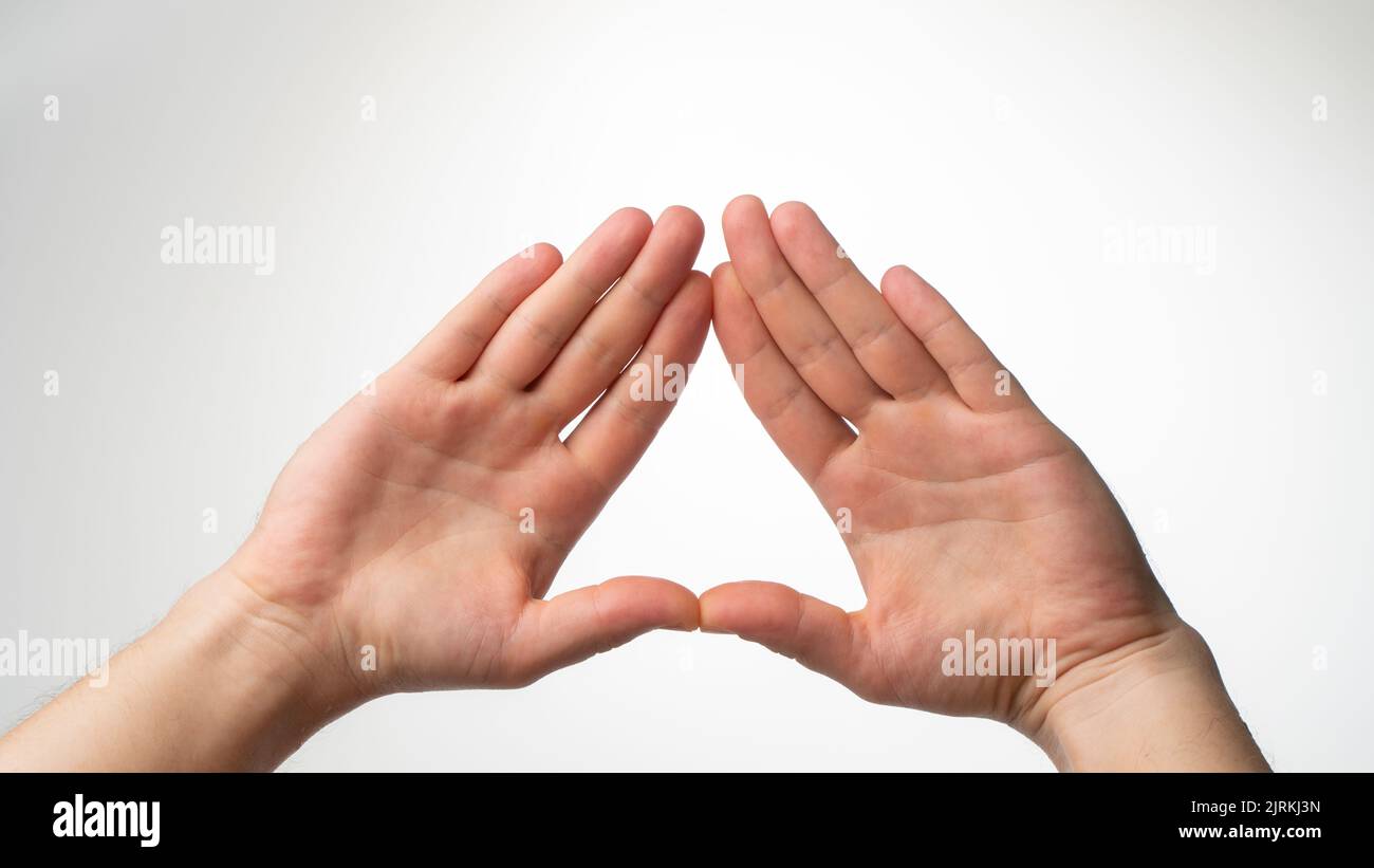 The man's palms are folded in a triangle on a white background. High quality photo Stock Photo