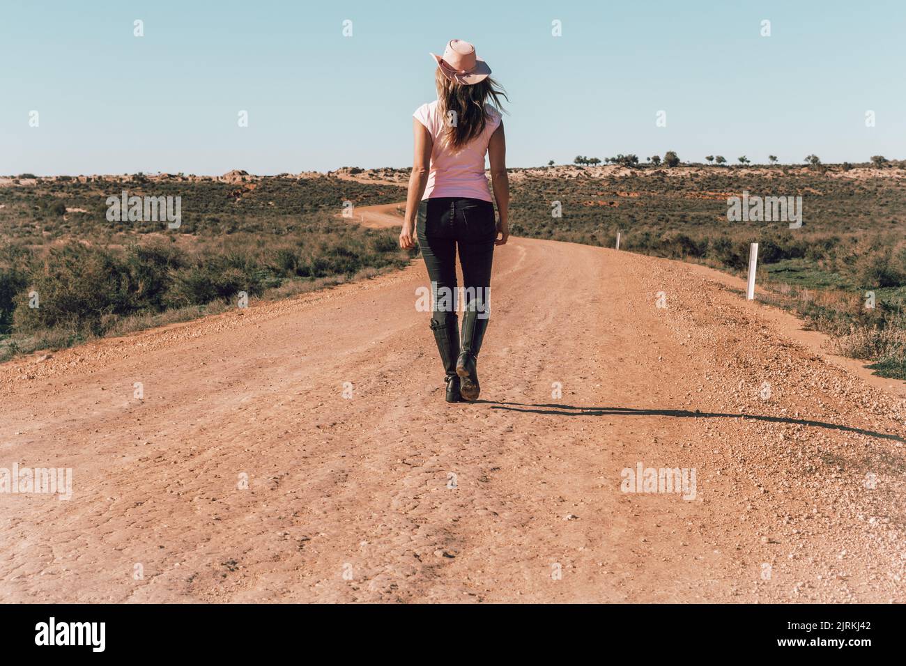 Woman walking dusty roads of outback Australia Stock Photo