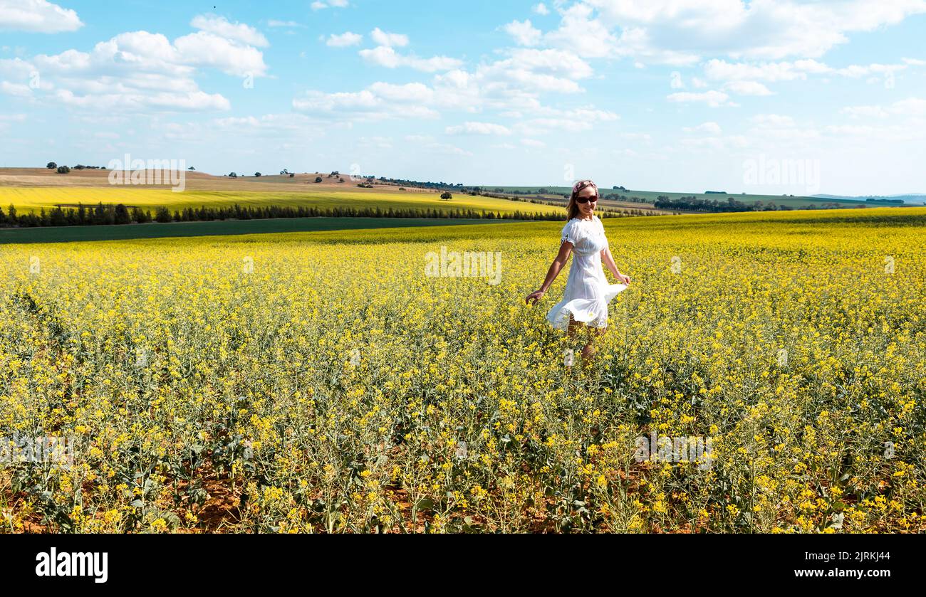 Woman frolicking in a field of flowers in teh spring time in rural country landscape Stock Photo