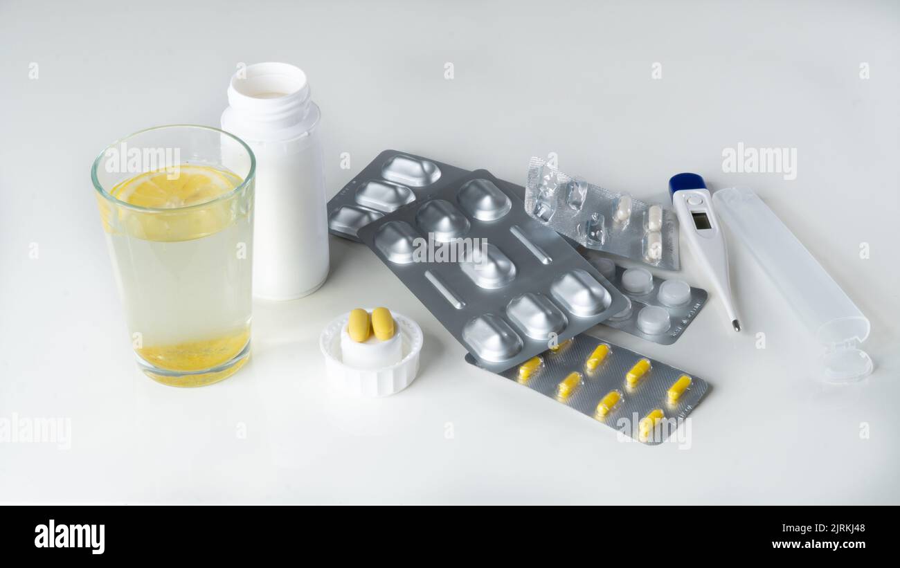 Medicines for treatment - tablets, pills, thermometer, water with lemon. High quality photo Stock Photo
