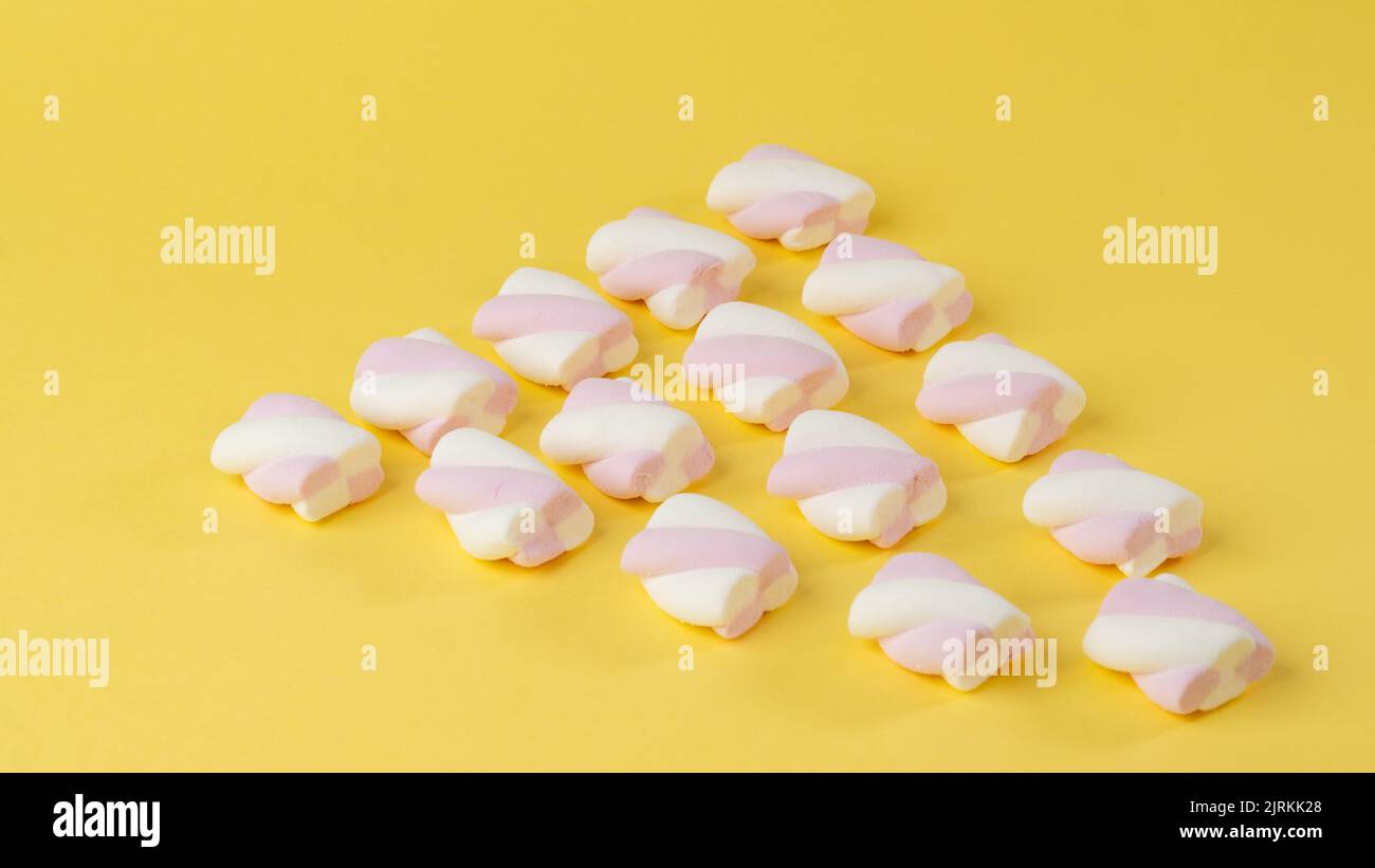 Background of marshmallow pigtails on a yellow background. High quality photo Stock Photo