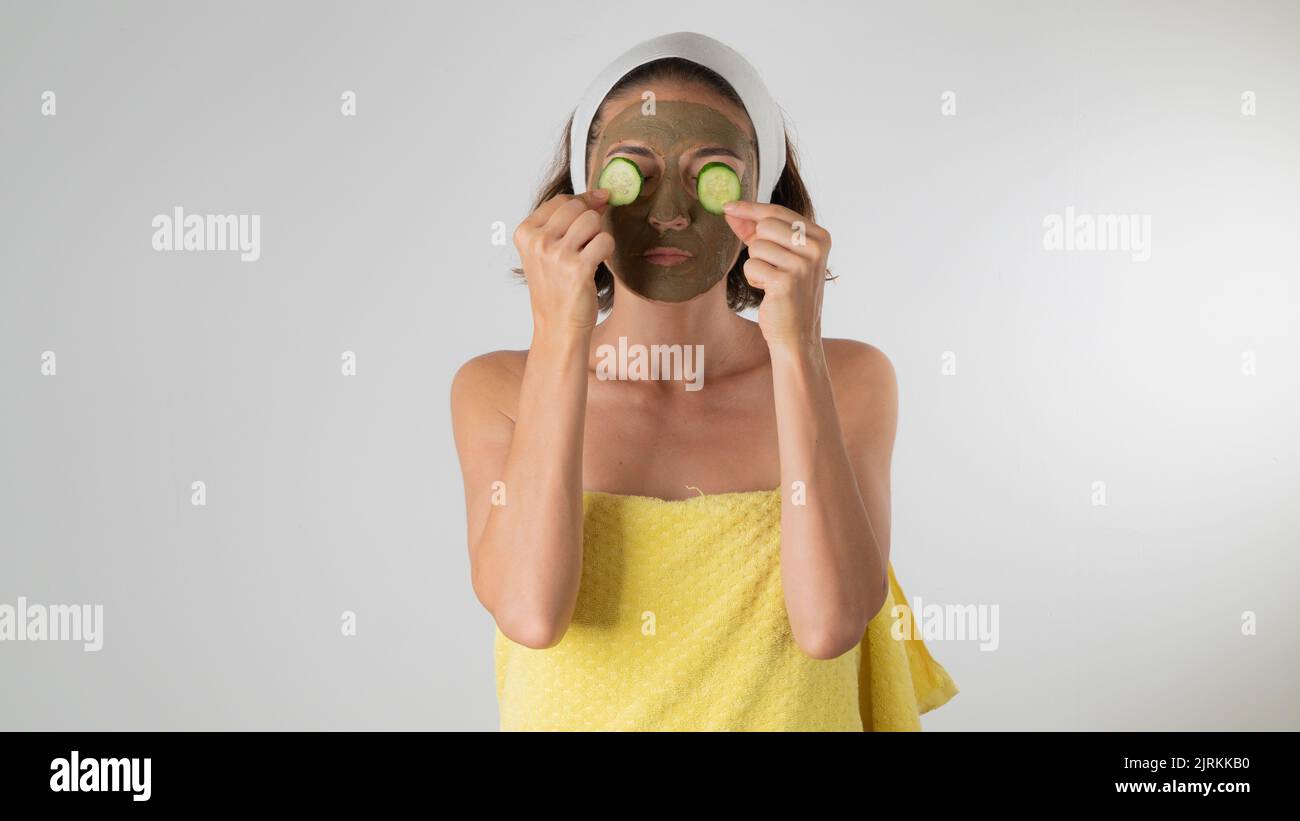 The woman makes a face mask and removes bags under the eyes with cucumber - self-care at home. High quality photo Stock Photo