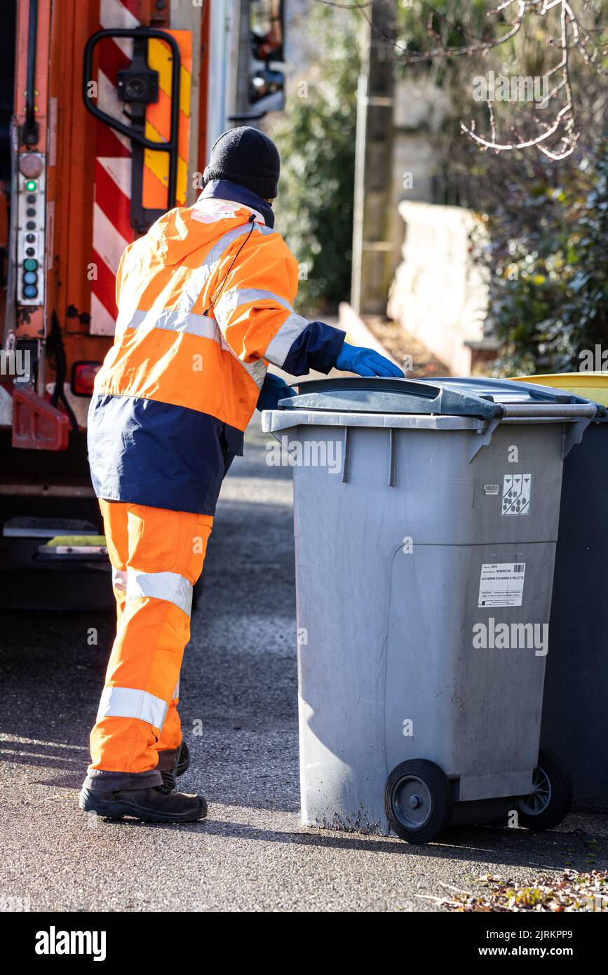 Waste collection service in the metropolis of Besancon (north-eastern France): dustman / garbage man collecting a garbage bin Stock Photo