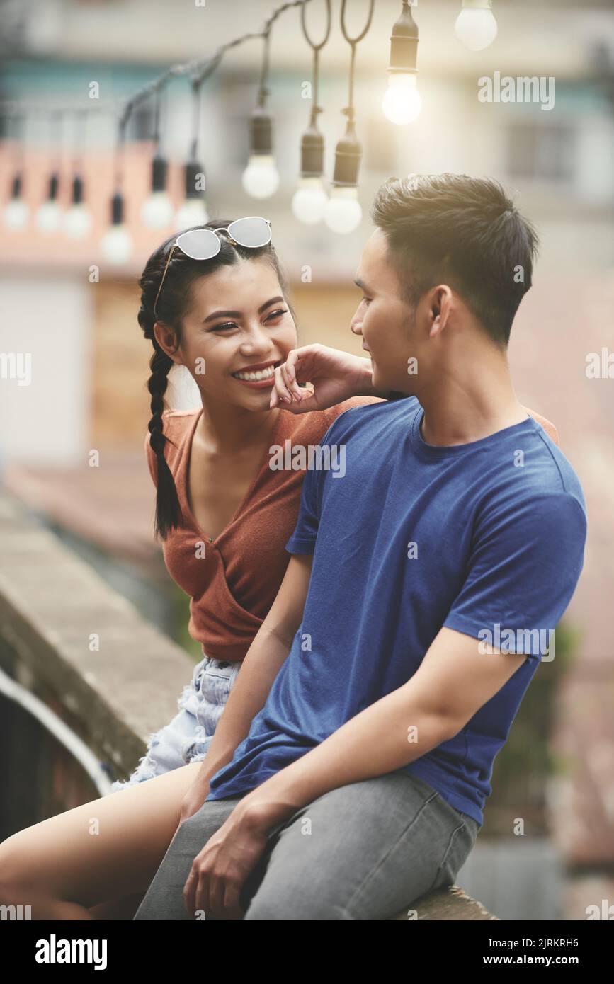 Young happy Asian couple having date outdoors Stock Photo