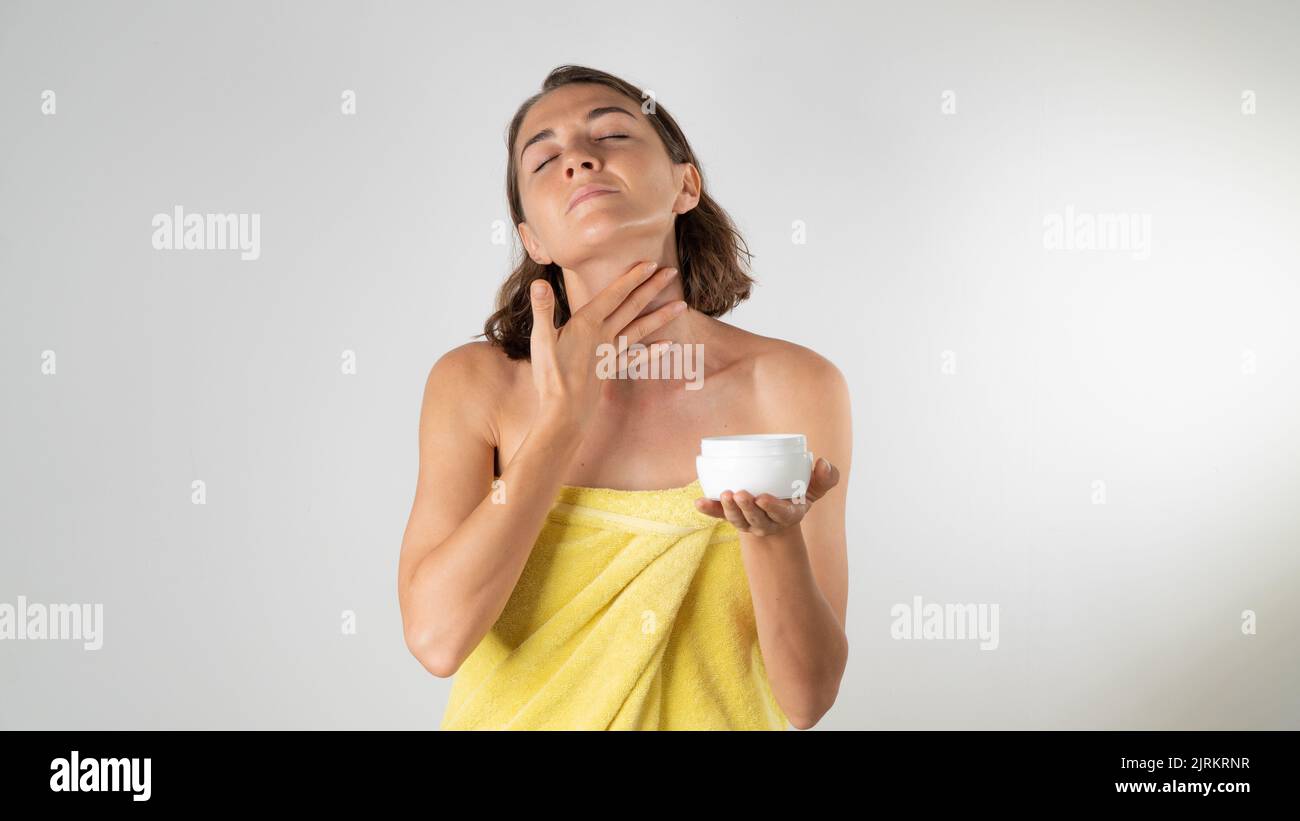 A woman applies cream to the neck - home care. High quality photo Stock Photo
