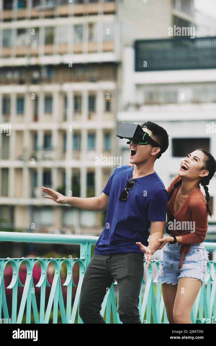 Excited young Vietnamese couple using VR goggles Stock Photo