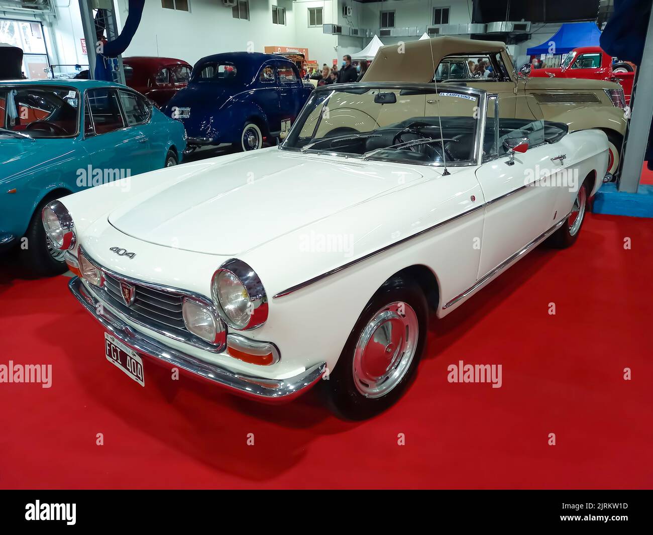 Berazategui, Argentina - Jul 22, 2022: Old white 1975 Peugeot 404 cabriolet convertible on the red carpet. Exhibit hall. Classic car show Stock Photo