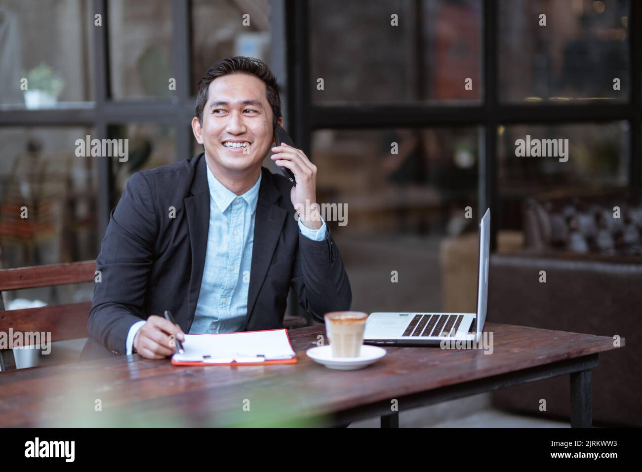 businessman having a phone call while working alone at cafe Stock Photo ...