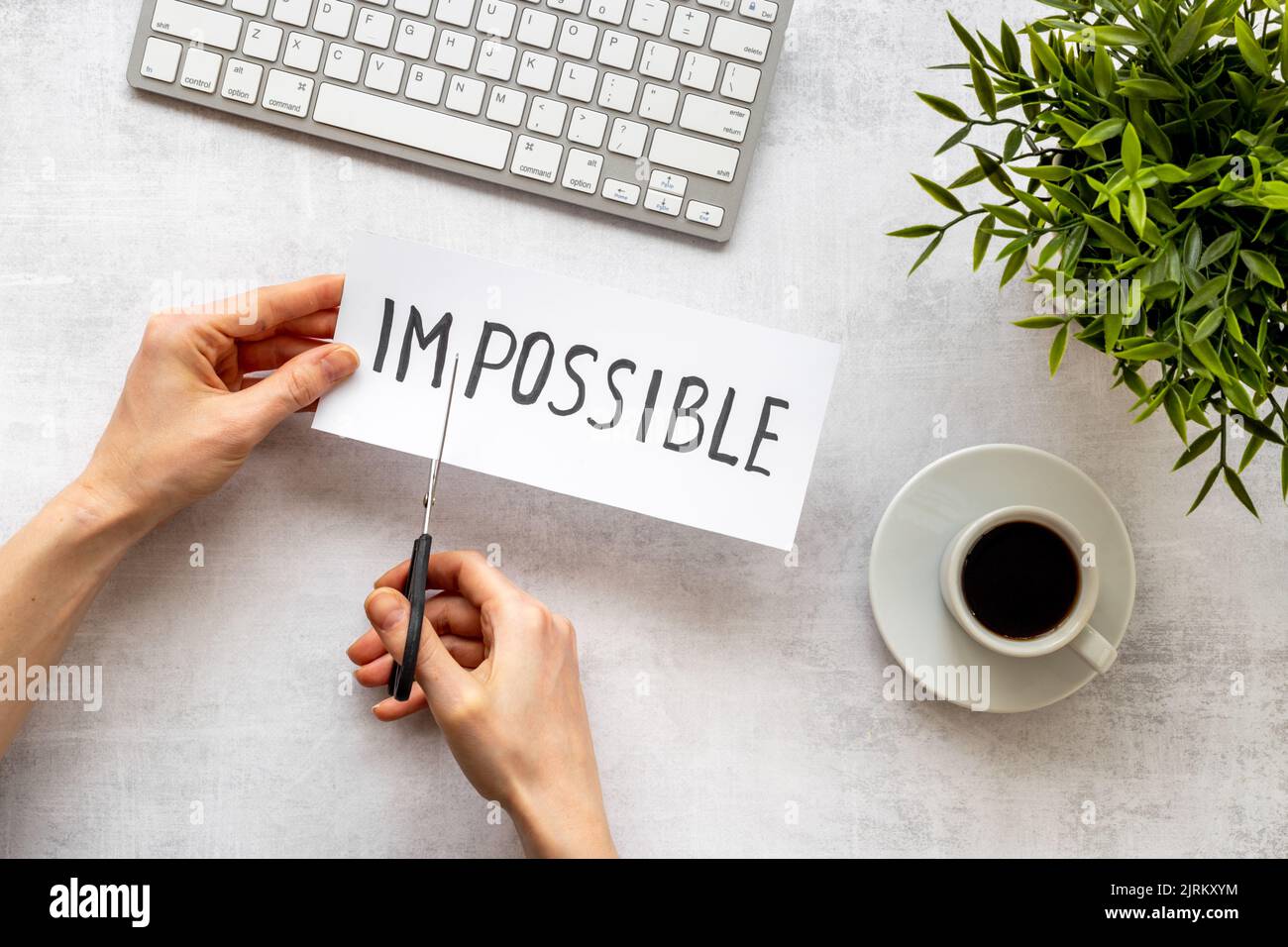 Hands cutting card with text Impossible into Possible. Motivation ...