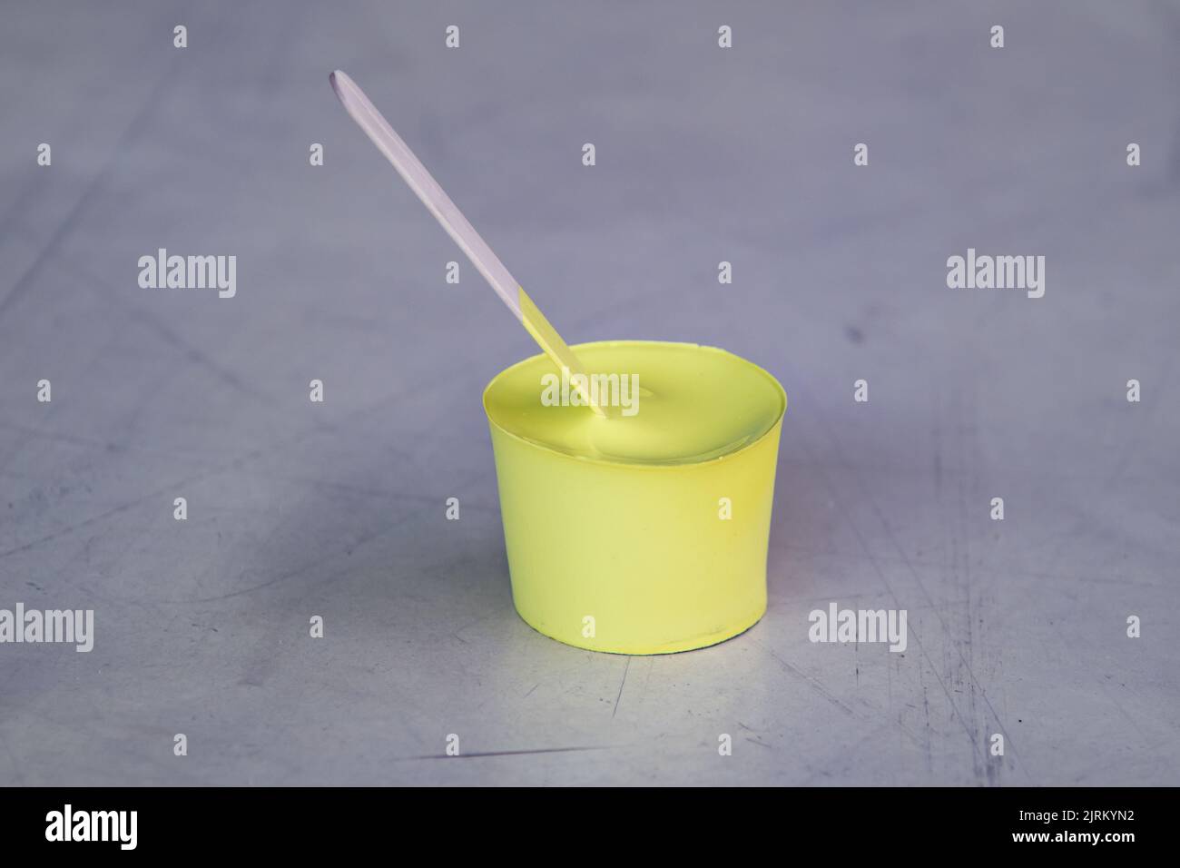 Yellow paint that has dried in the container and taken shape like a ...