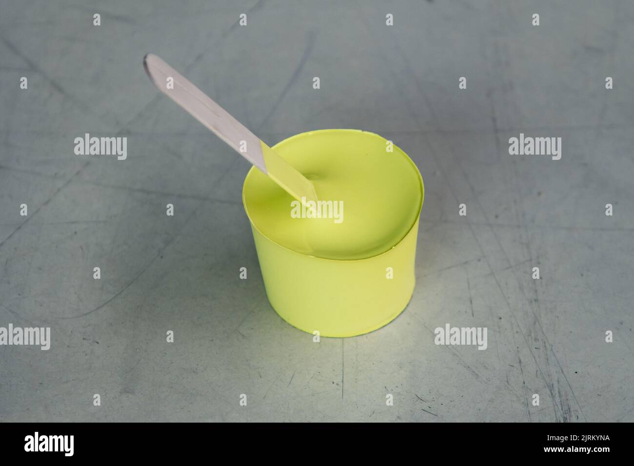 Yellow paint that has dried in the container and taken shape like a ...