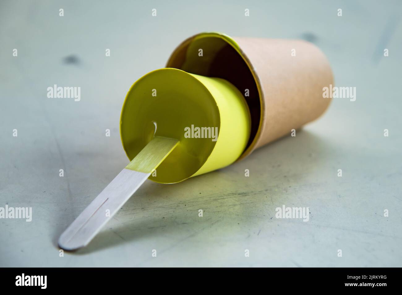 Yellow paint that has dried in the container and taken shape like a mold Stock Photo