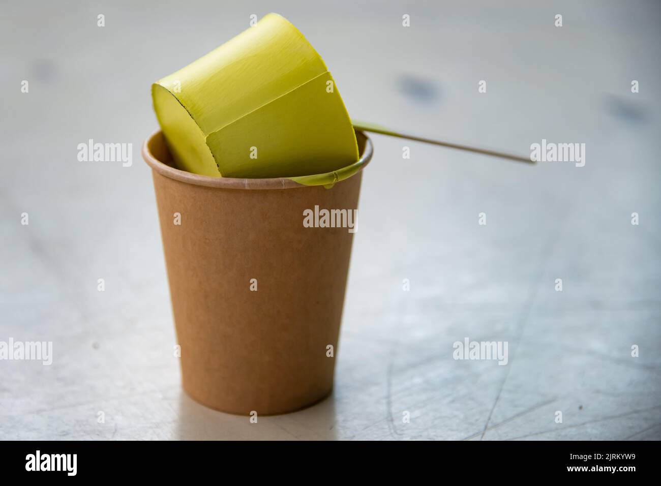 Yellow paint that has dried in the container and taken shape like a ...