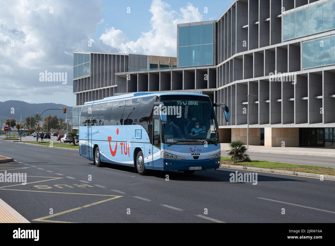 A large blue coach bus in a street near a modern building, Palma, Spain Stock Photo