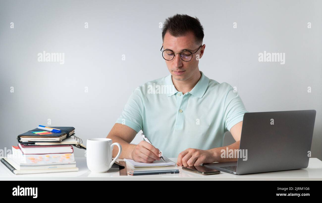Student writes in notebooks - training, exam preparation, online education. High quality photo Stock Photo
