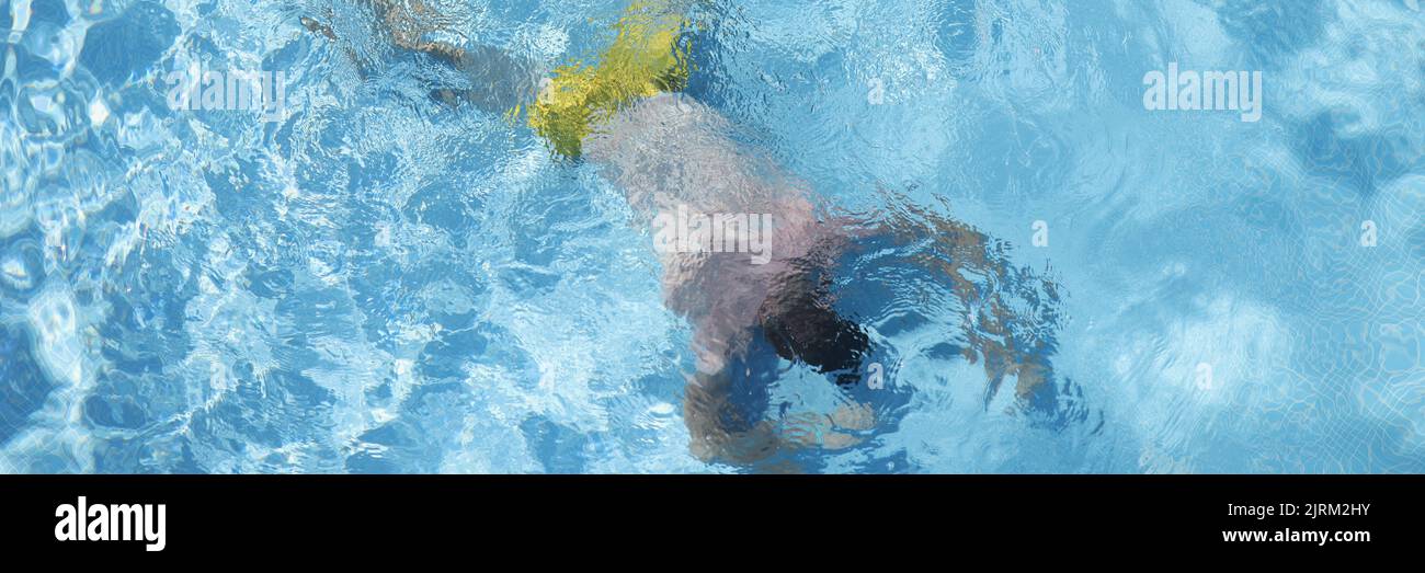 Man lying at bottom of swimming pool top view Stock Photo