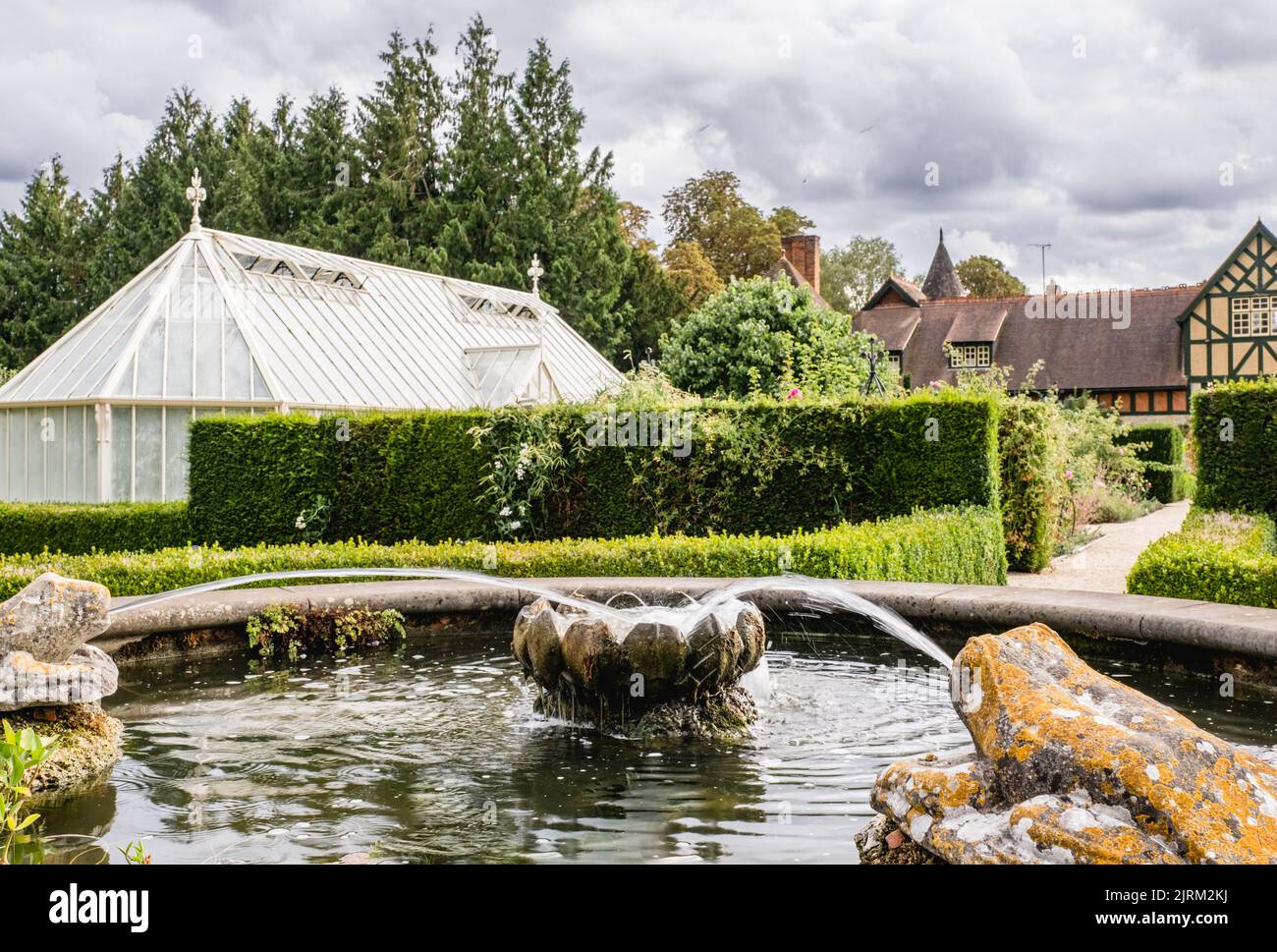 The ornamental fountain and green houses in the background at Eythrope Gardens on the Waddesdon Manor estate. Stock Photo