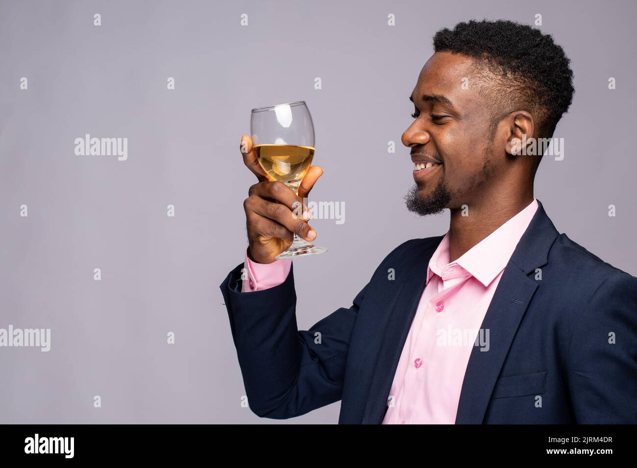 black man smiles while holding a wine glass Stock Photo