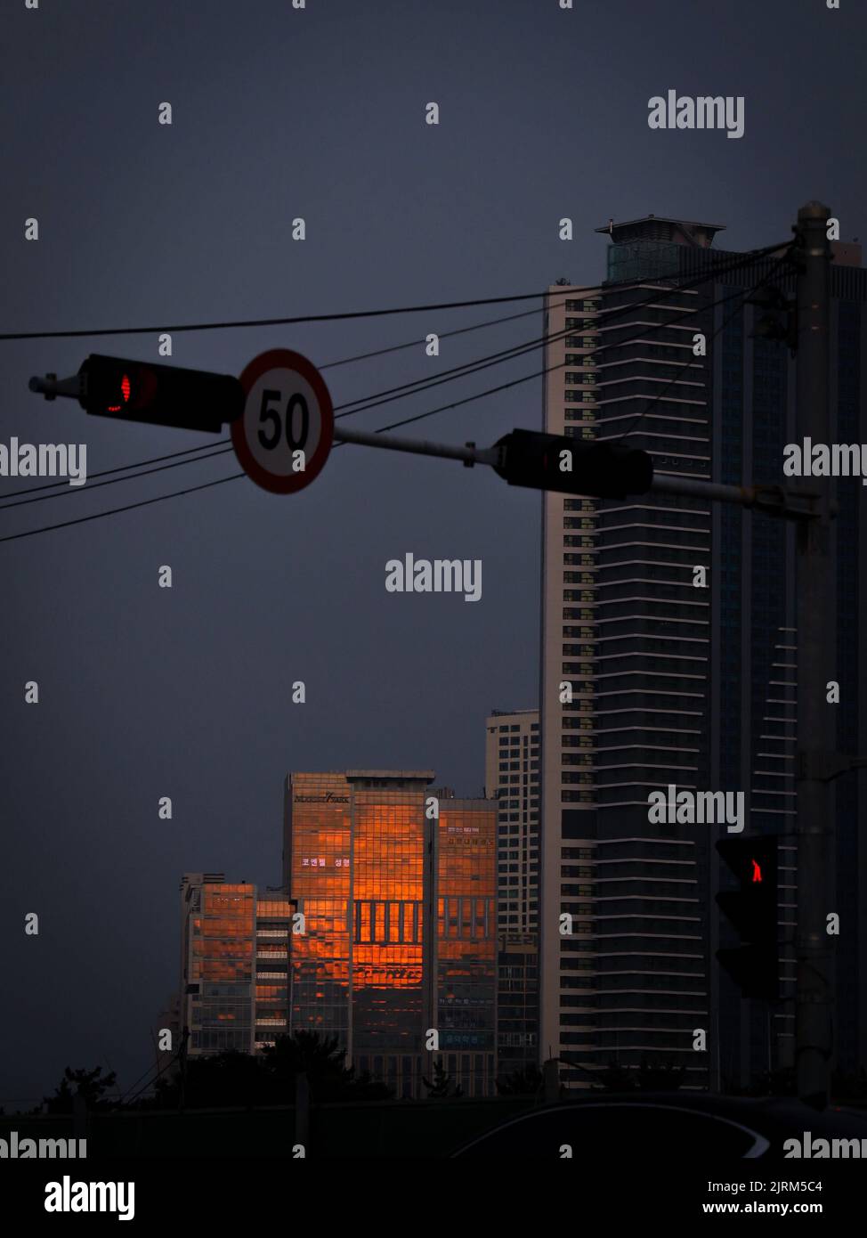 Speed Limit Building A vertical shot of a speed limit sign and traffic light against ...