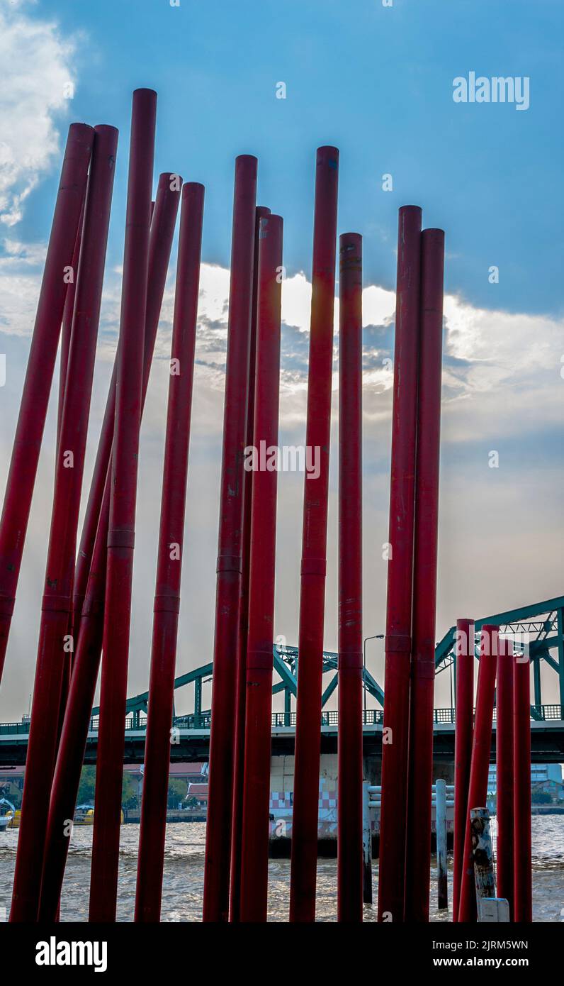 Red poles for construction standing with a bridge in the background. Stock Photo