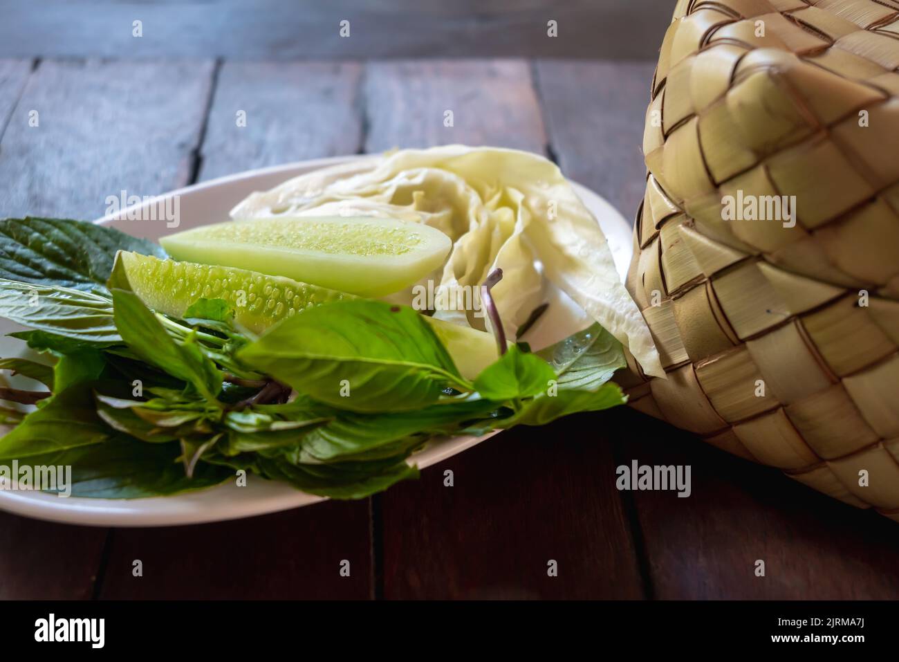 https://c8.alamy.com/comp/2JRMA7J/bamboo-wicker-sticky-rice-basket-called-kratip-in-the-northeastern-province-thailand-served-with-a-vegetable-side-dish-on-the-wooden-table-2JRMA7J.jpg