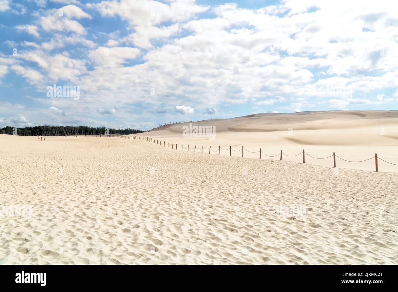 Lacka dune in Slowinski National Park in Poland, a miracle of nature. Traveling dune in sunny summer day. Sandy beach and blue sky with white clouds. Stock Photo