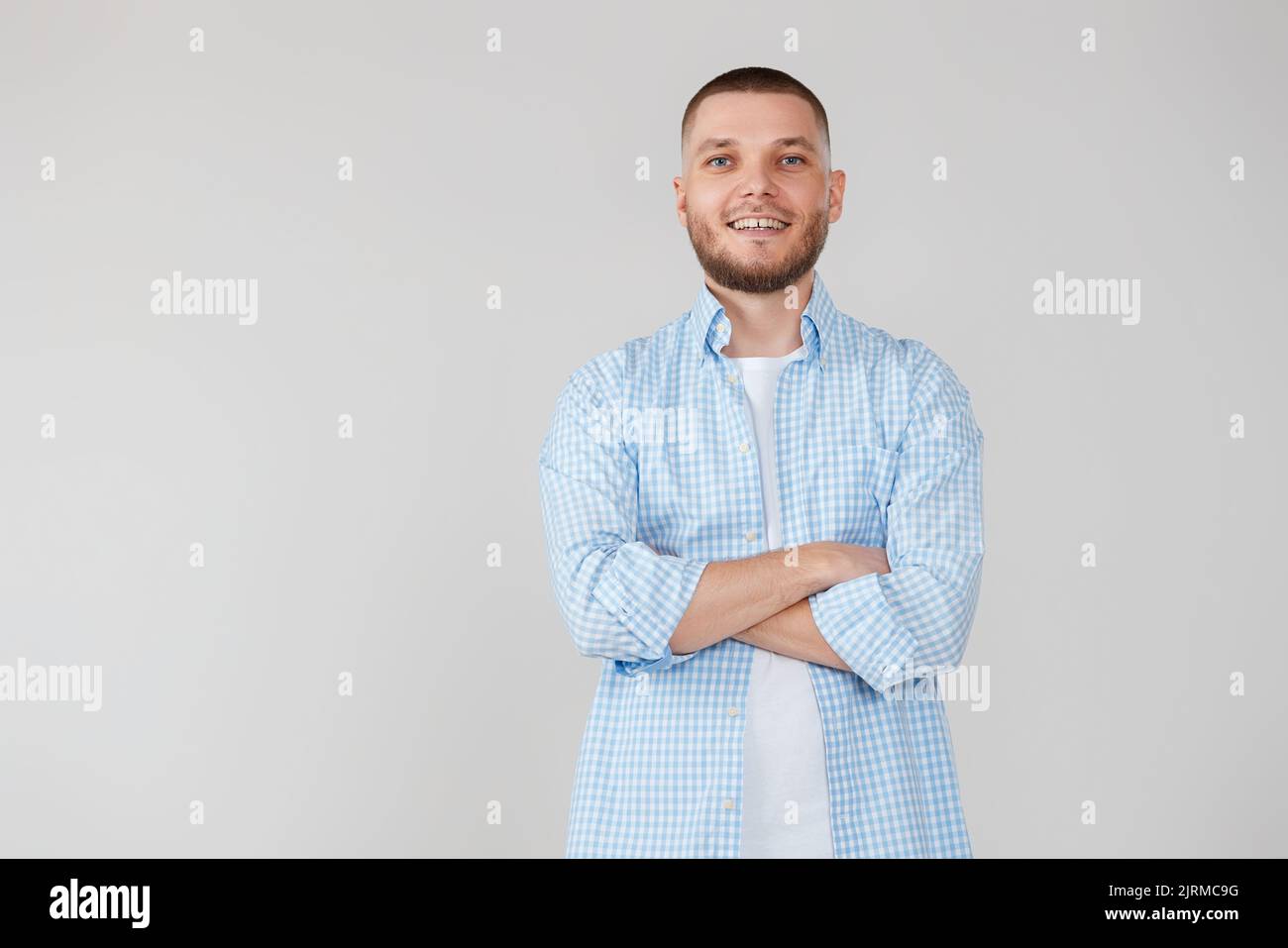smiling young guy posing with crossed arms Stock Photo