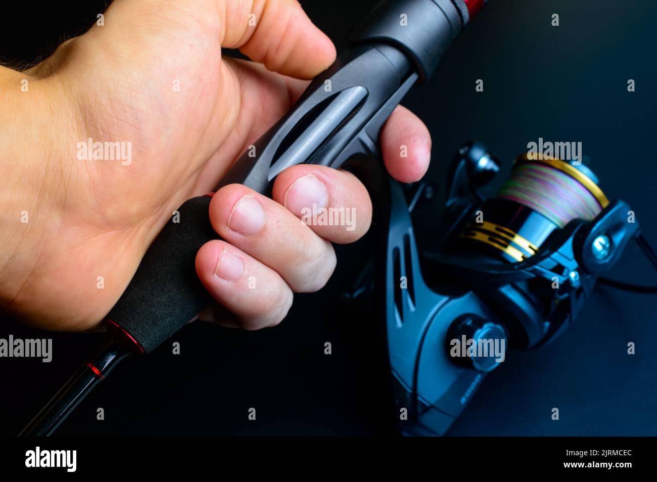 A child's hand holding Fishing rod with reel. Stock Photo